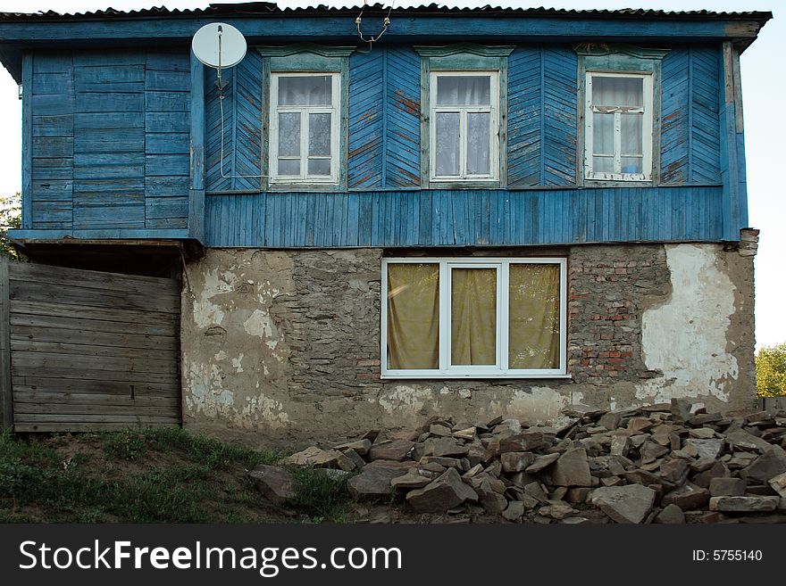 The old house with new windows and satellite антеной as a symbol of arrival of new time in a traditional way of life. The old house with new windows and satellite антеной as a symbol of arrival of new time in a traditional way of life