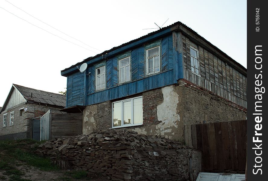 The old house with new windows and satellite Ð°Ð½Ñ‚ÐµÐ½Ð¾Ð¹ as a symbol of arrival of new time in a traditional way of life. The old house with new windows and satellite Ð°Ð½Ñ‚ÐµÐ½Ð¾Ð¹ as a symbol of arrival of new time in a traditional way of life