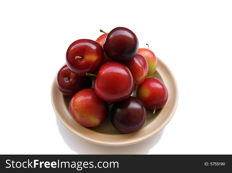 Plums on plate isolated on white background