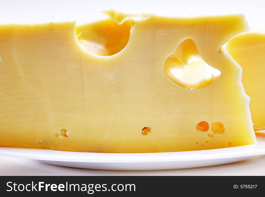 Big piece of cheese on the plate. Close-up. Narrow depth of field. Big piece of cheese on the plate. Close-up. Narrow depth of field.