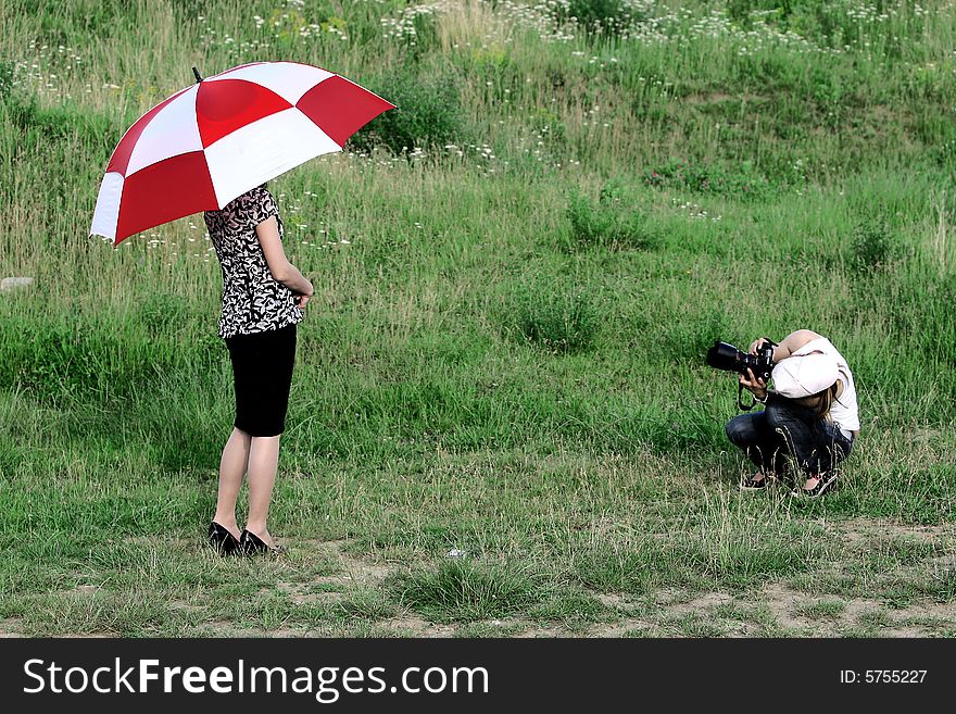 Two girls, an umbrella and a photo camera. Two girls, an umbrella and a photo camera