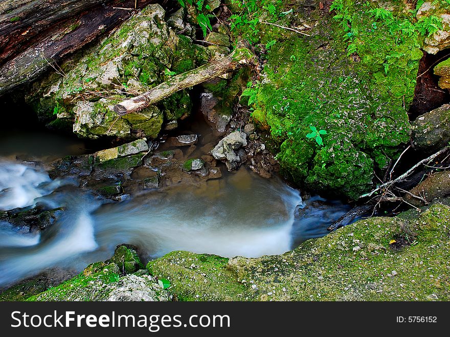 This is an area of a dam on a small creek. The water has broke through on one side.The view is taken from the top of the dam looking down. This is an area of a dam on a small creek. The water has broke through on one side.The view is taken from the top of the dam looking down.