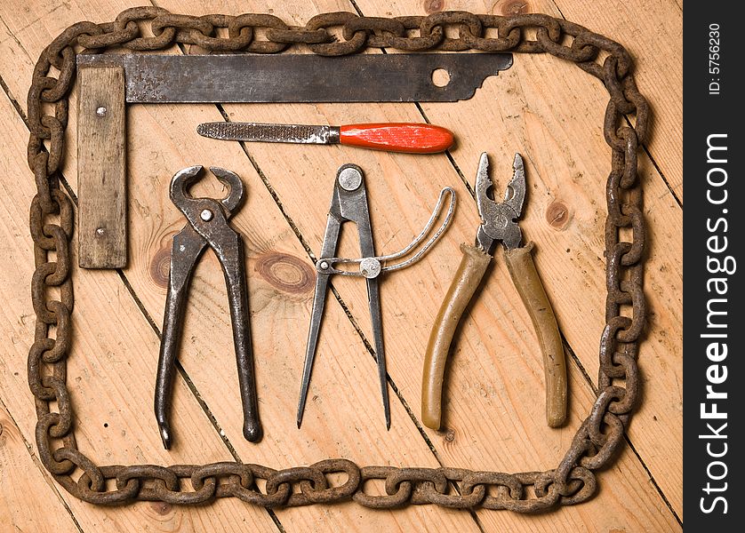 Old tools lay on wooden to a floor.