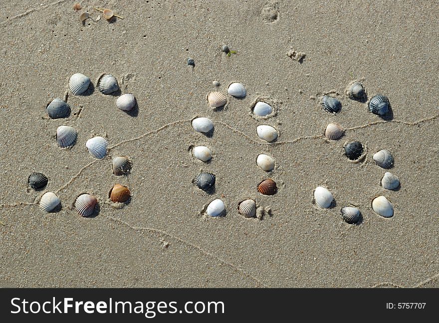 SOS signal on the sand made from shells