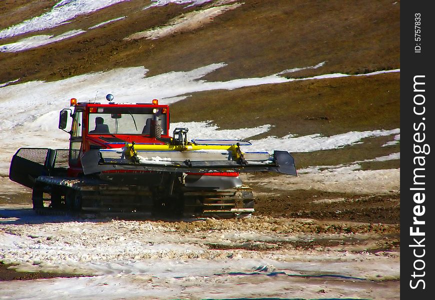Snow plow in ski resort, beginning of spring when the snow thaws