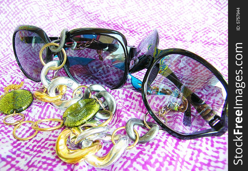 Sunglasses on a color background with a beads