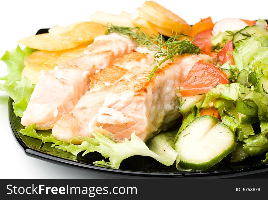 Stake from a salmon with vegetables on a plate. Closeup.