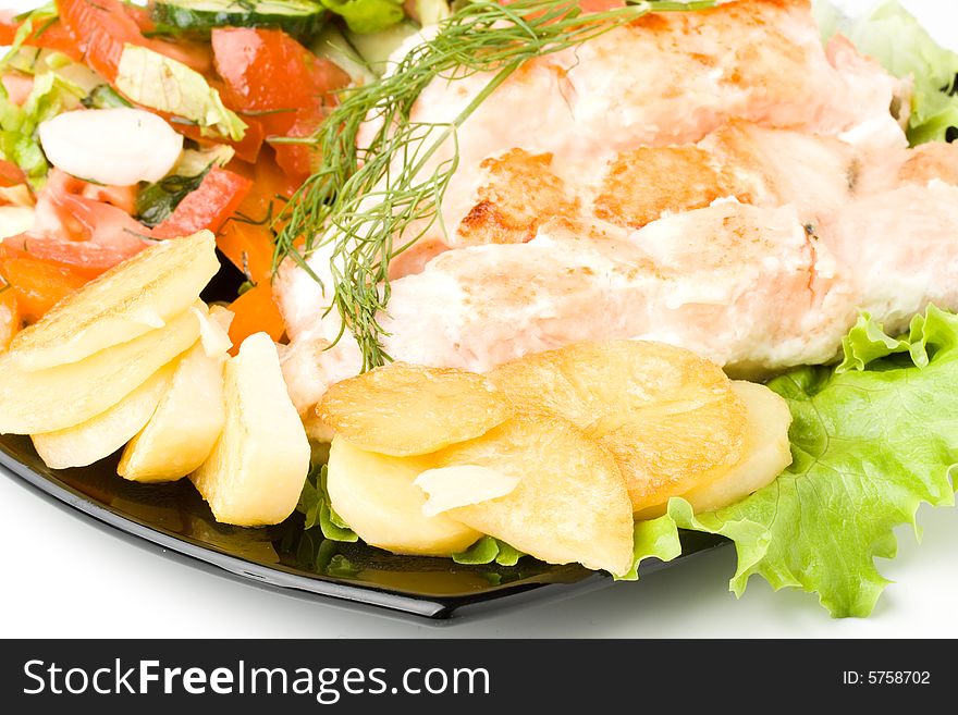 Stake from a salmon with vegetables on a plate. Closeup.