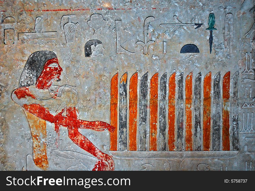 Ancient egyptian painting with hieroglyphs engraved in stone