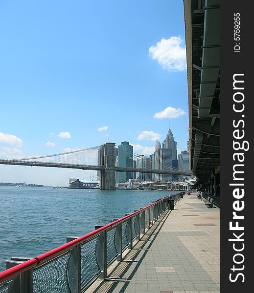 Path along New York's East River. Brooklyn Bridge in the distance.