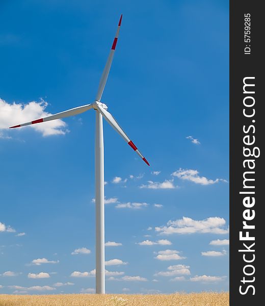 Windmill with yellow field and blue sky background