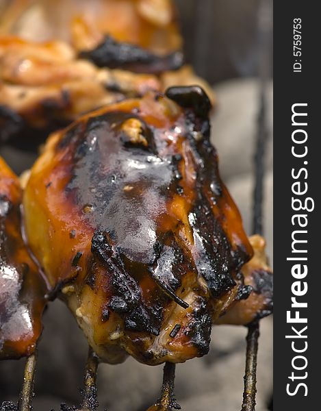 Chicken pieces being grilled on charcoals of hibachi grill. Chicken pieces being grilled on charcoals of hibachi grill.