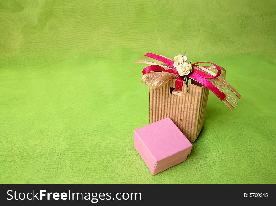 Pink gift box and brown gift bag with ribbons