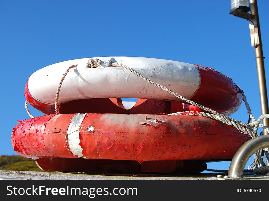 Two lifebuoys on top of a boat with a blue sky. Two lifebuoys on top of a boat with a blue sky