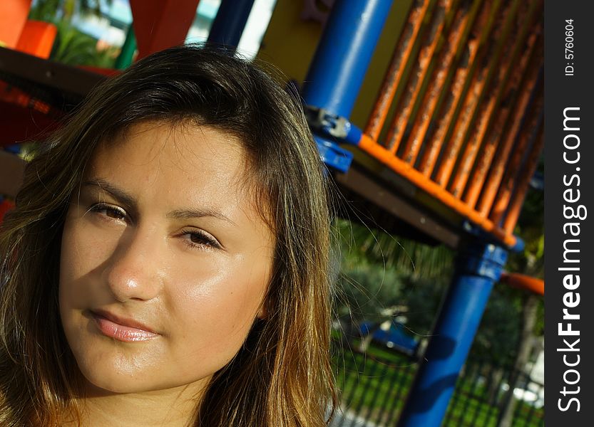 Headshot of a young female with a playground in the background. Headshot of a young female with a playground in the background.