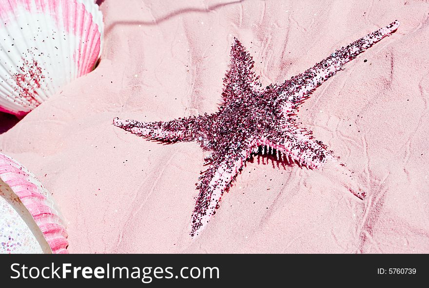 Sparkling starfish and shells on pink sand. Vacation and sea concept.