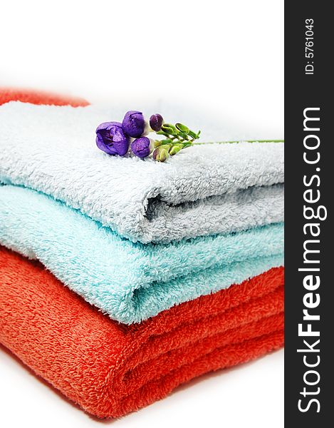 Towels in pile and violet flower. Towels in pile and violet flower