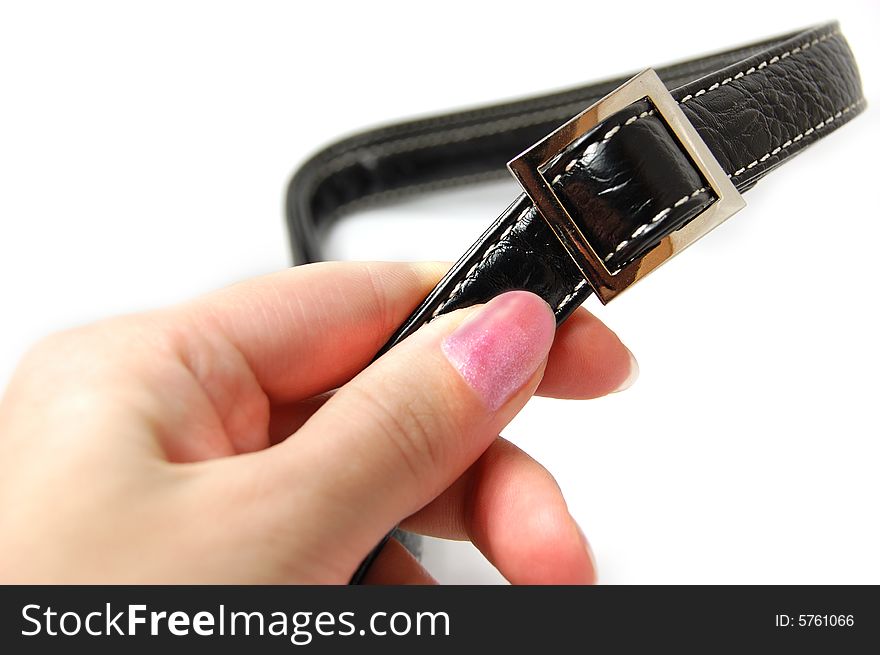 Female hand holding black buckle on white