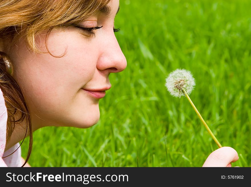 Girl blowing on the dandelion