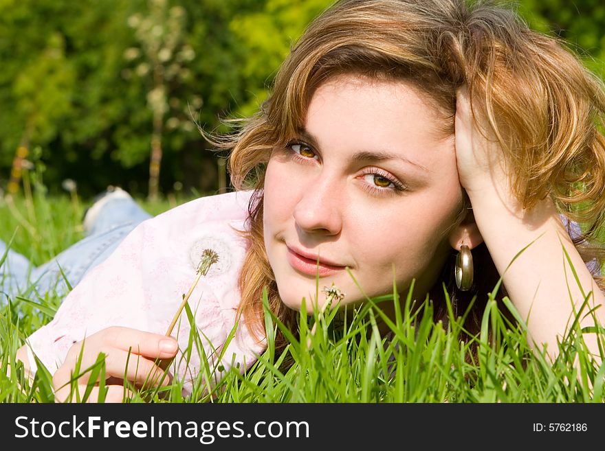 Happy girl blowing on the dandelion