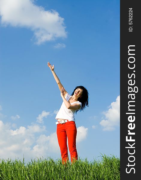 Woman on a green meadow and show something