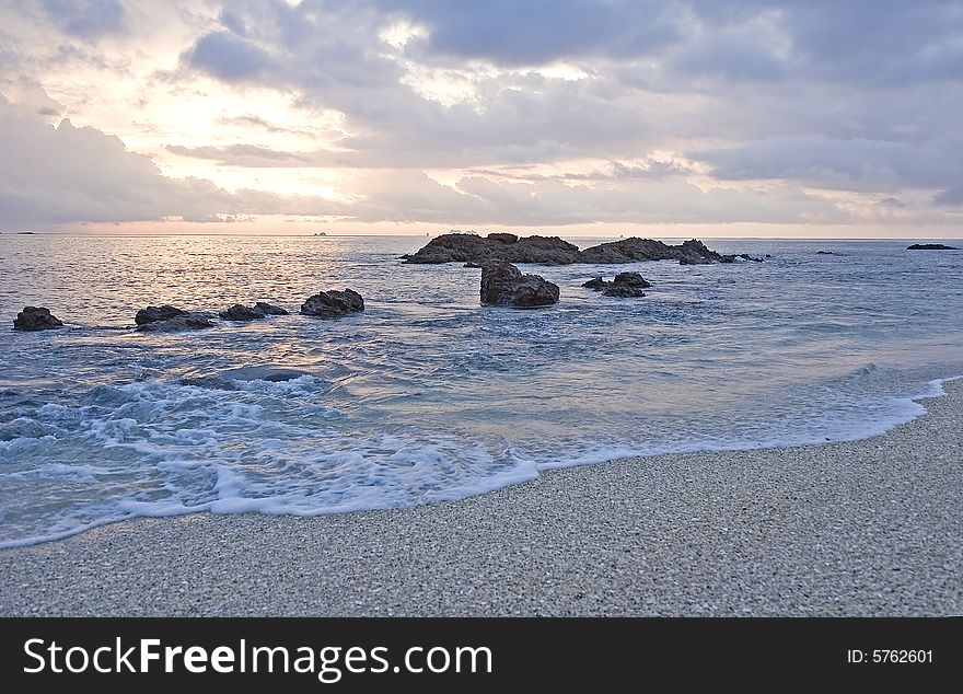 Sunset on a beach with a rocky surf. Sunset on a beach with a rocky surf