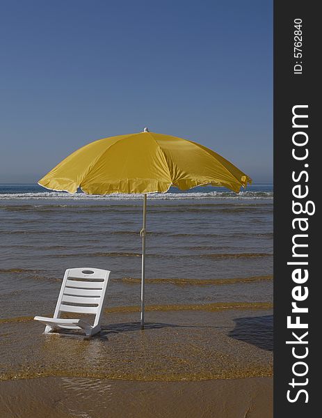 Two beach umbrellas on empty beach and bright blue ocean.Best beach  - Algarve - Portugal. Two beach umbrellas on empty beach and bright blue ocean.Best beach  - Algarve - Portugal