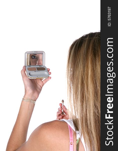 Teenage girl applying makeup in a compact mirror. Teenage girl applying makeup in a compact mirror