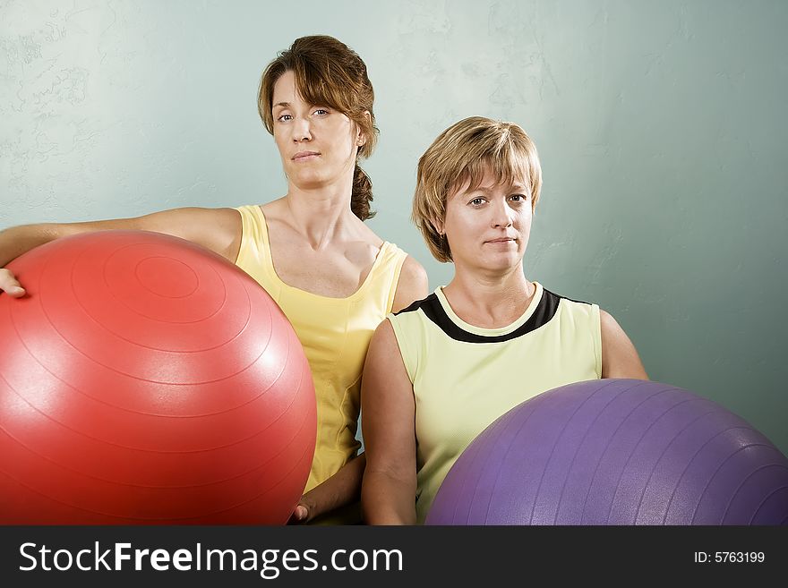Two Physically Fit Women Posing With Exercise Balls