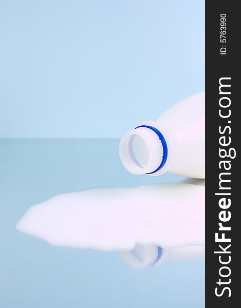 Spilt full cream milk isolated against a blue background. Spilt full cream milk isolated against a blue background