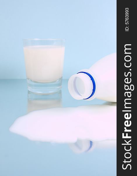 Spilt full cream milk isolated against a blue background. Spilt full cream milk isolated against a blue background