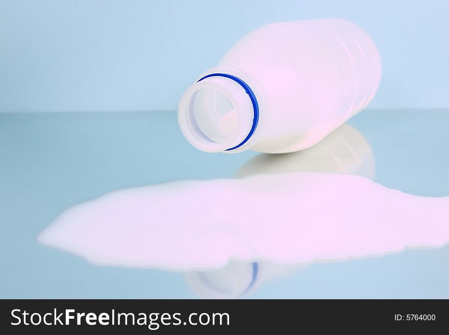 Spilt full cream milk isolated against a blue background. Spilt full cream milk isolated against a blue background