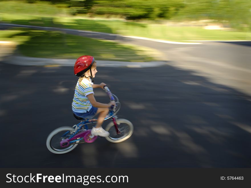 Little girl riding a bike wearing a helmet