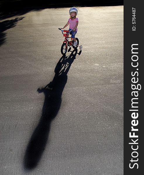 Little girl riding a bike wearing a helmet