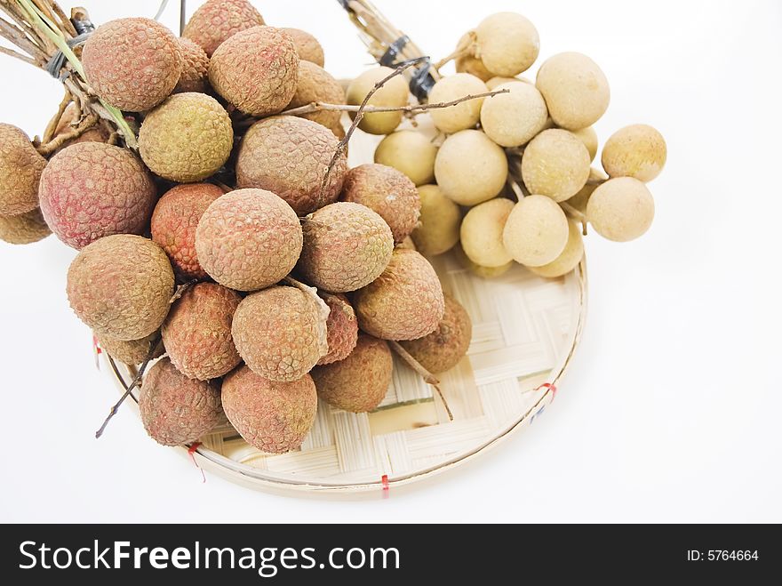 Lychee and longan fruits on woven bamboo tray. Lychee and longan fruits on woven bamboo tray