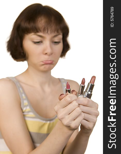 A photo of a young girl choosing a lipstick. A photo of a young girl choosing a lipstick