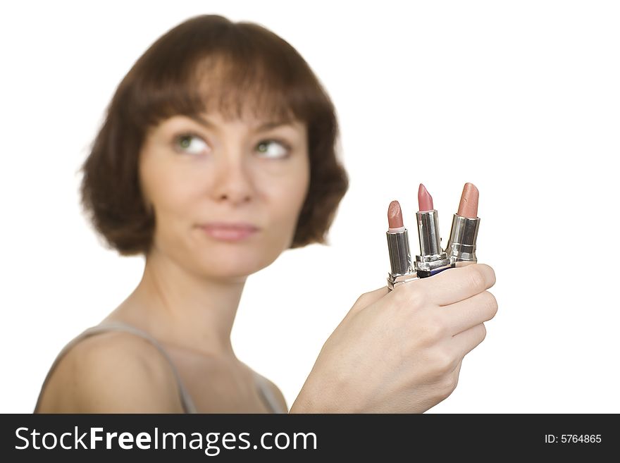 A photo of a young girl choosing a lipstick. A photo of a young girl choosing a lipstick