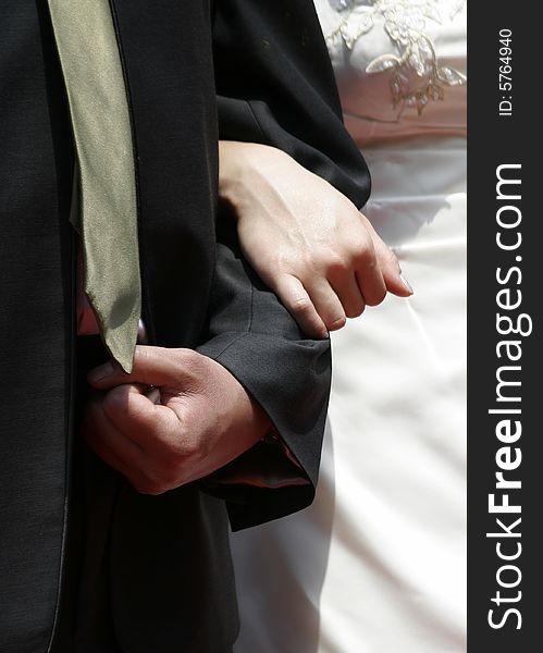 A bride holding the arm of the bridegroom during a wedding ceremony. A bride holding the arm of the bridegroom during a wedding ceremony.
