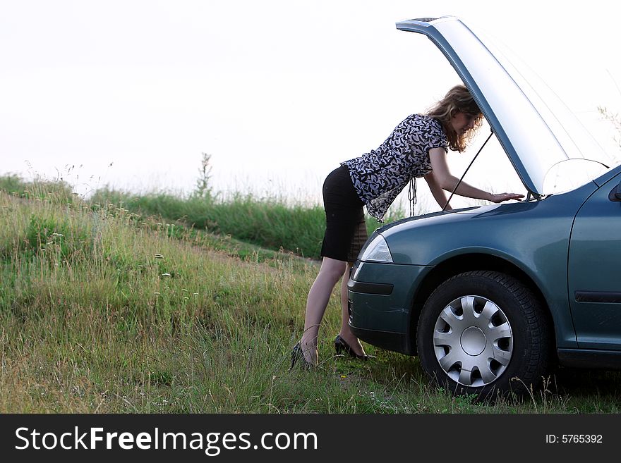 A beautiful girl trying to repair the car