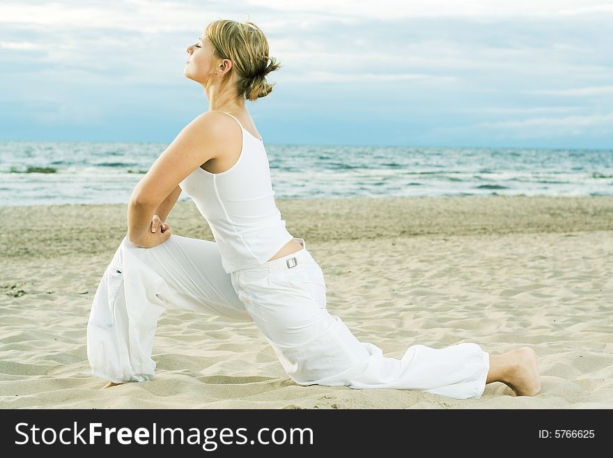 Young cute girl training on the beach. Young cute girl training on the beach.