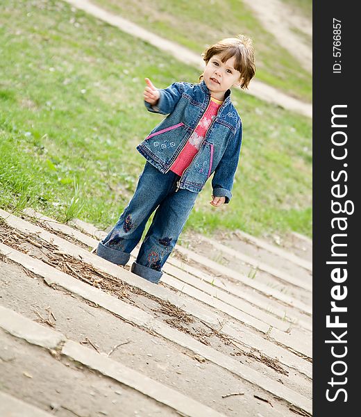 Little cute girl standing alone on the stairs in a park. Little cute girl standing alone on the stairs in a park