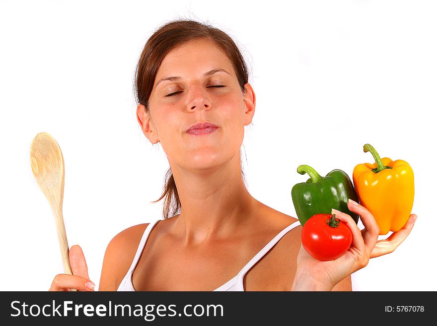 A young woman with peppers and a spoon in her hands dreams. Ideal cooking / diet / houswife shot. A young woman with peppers and a spoon in her hands dreams. Ideal cooking / diet / houswife shot.