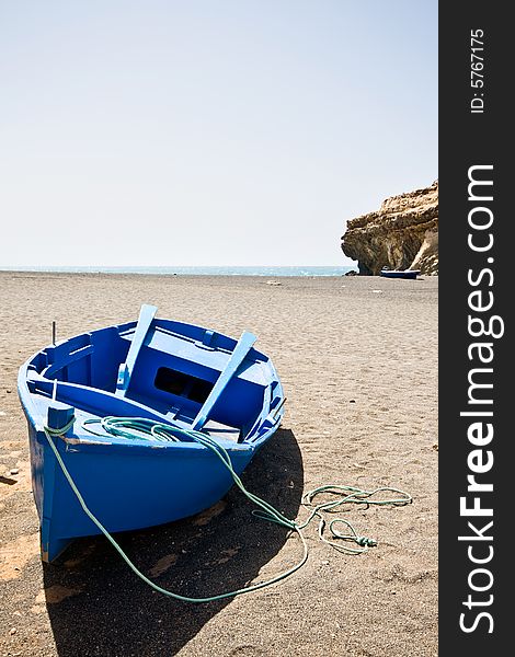 A blue boat on the beach.