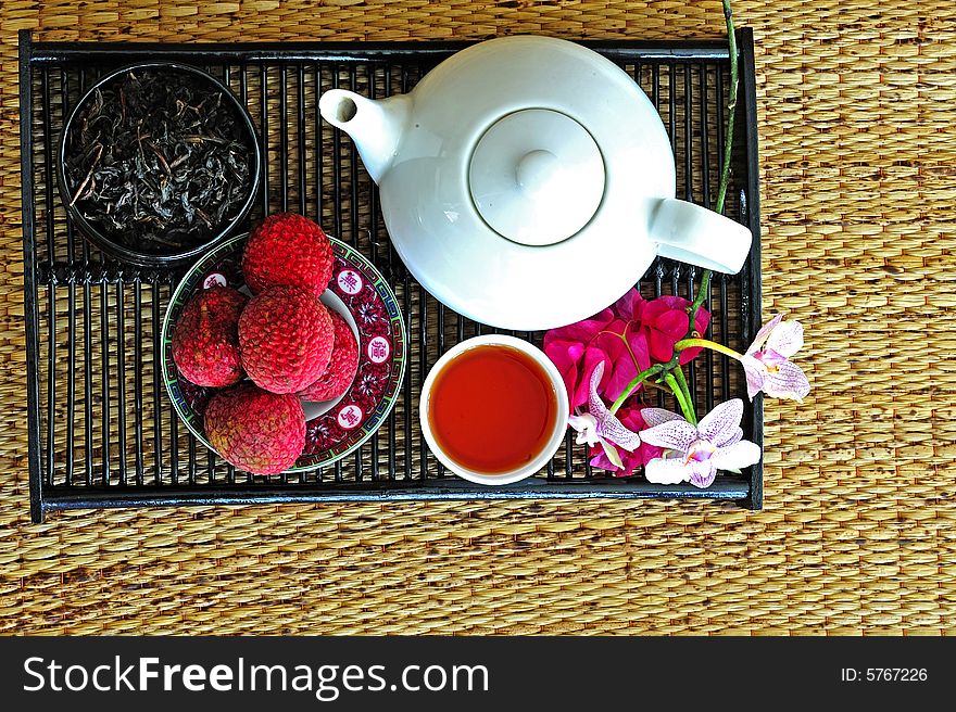 Asian pottery tea set with chinese tea and litchees