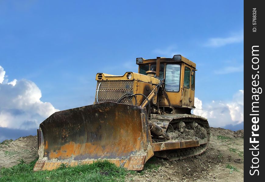 Old and rusty bulldozer stands on barren terrain