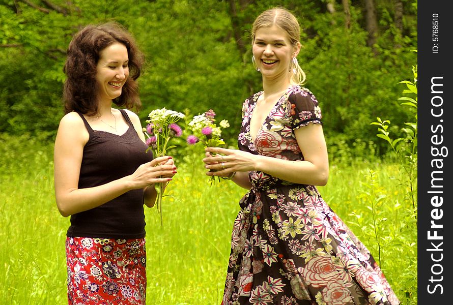 Two women pick up flowers. Two women pick up flowers