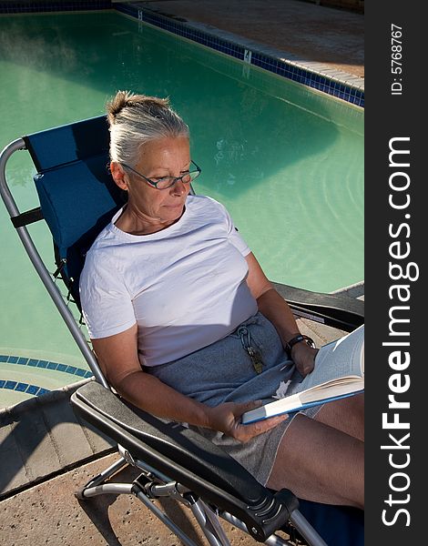 Senior Woman Sitting By Pool