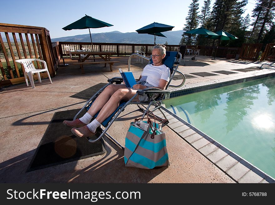 Senior Woman Sitting By Pool