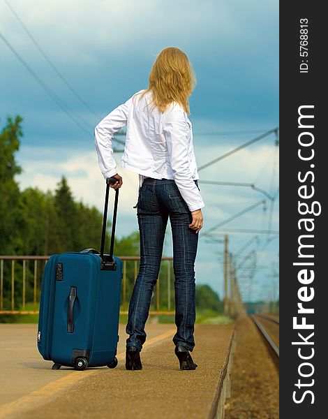 Beautiful young lady with big suitcase waiting for a train. Beautiful young lady with big suitcase waiting for a train