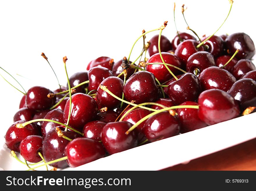 Sweet red cherries on a white plate, ready to eat. Sweet red cherries on a white plate, ready to eat.
